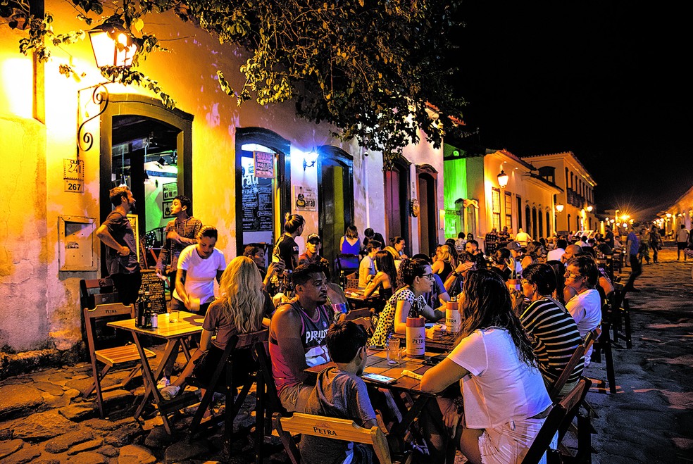 Frequentadores dos bares nos arredores da Praça da Matriz, no centro histórico de Paraty, no Estado do Rio — Foto: Luciola Villela / Agência O Globo