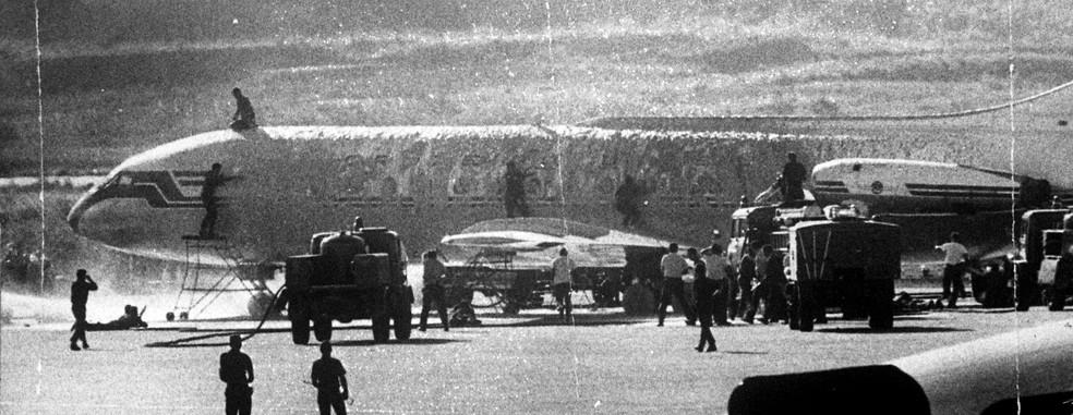 O avião cercado por forças de segurança, que tentam entrar na aeronave durante o sequestro, em 1970 — Foto: Arquivo/Agência O GLOBO