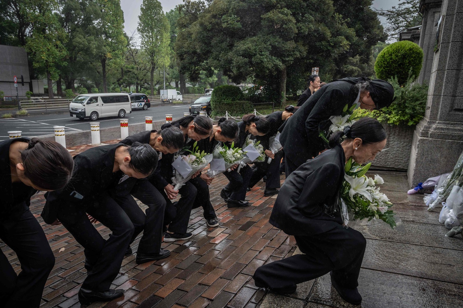 Membros de uma companhia de balé depositaram flores do lado de fora da embaixada britânica após a morte da Rainha Elizabeth II, em Tóquio — Foto: Yuichi YAMAZAKI / AFP