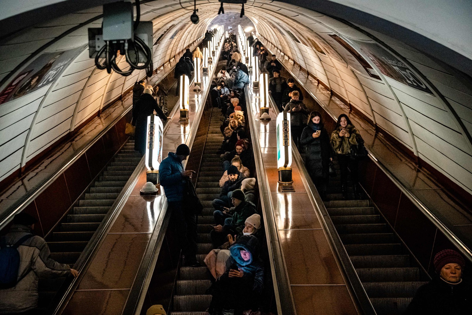 Civis sentam na escada de uma estação de metrô durante ataque aéreo em Kyiv — Foto: DILKOFF / AFP