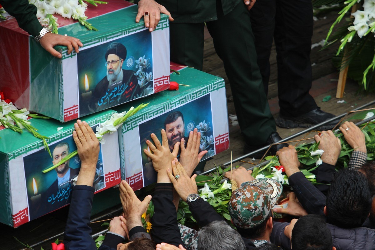 Pessoas participam de um cortejo fúnebre ao lado de um caminhão que transporta os caixões do presidente Ebrahim Raisi e seus sete assessores em Tabriz, província do Azerbaijão Oriental, em 21 de maio de 2024. — Foto: ATA DADASHIMOJ/News Agency/AFP