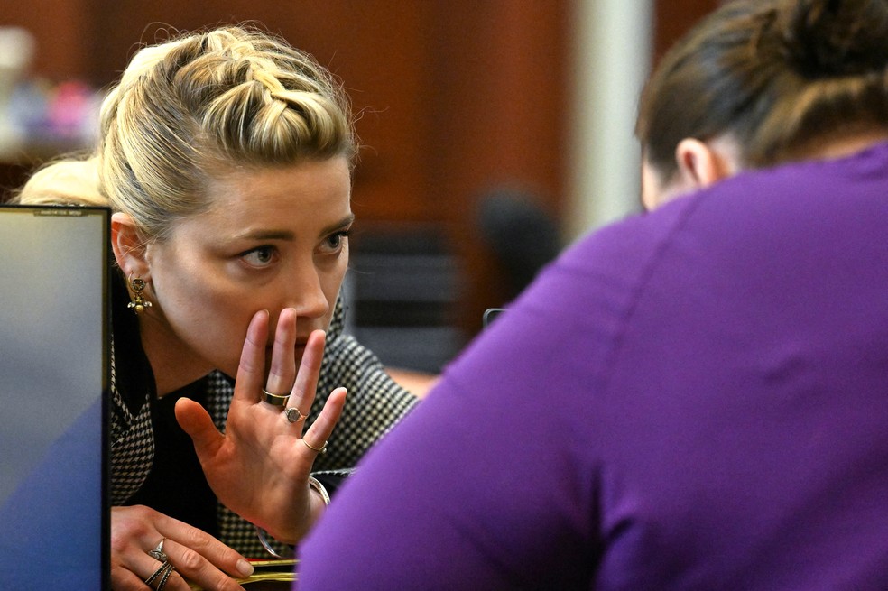 Amber Heard fala com um membro da equipe jurídica no Tribunal de Justiça do Condado de Fairfax, na Virgínia, EUA, em 24 de maio de 2022 — Foto: Jim Watson / REUTERS