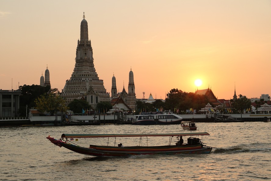 Passeio de barco pelo Rio Chao Phraya, em Bangkok, com o templo Wat Arun ao fundo