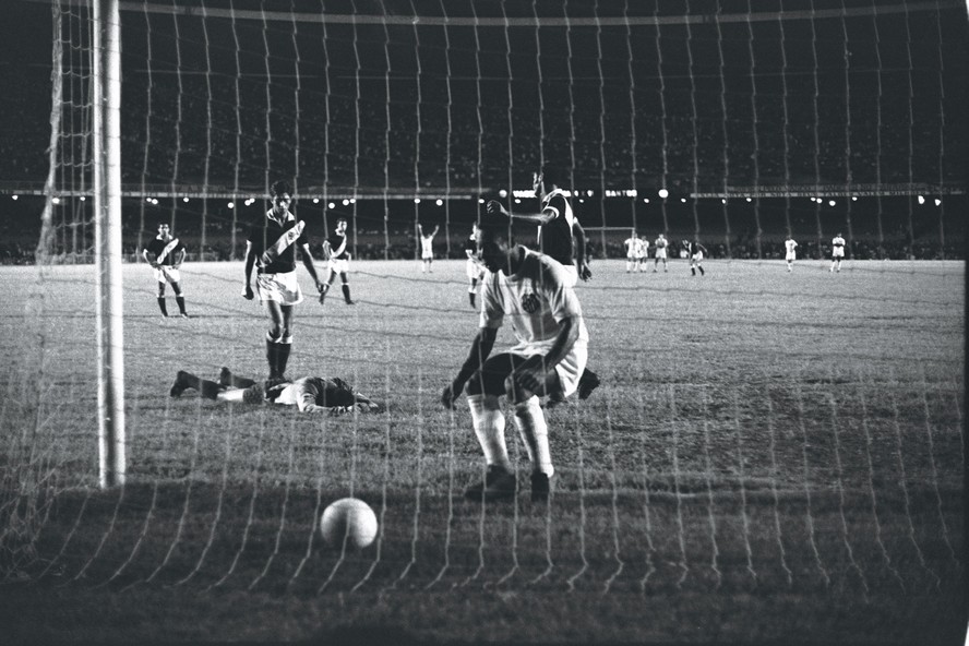 Com o goleiro Andrada caído ao fundo, Pelé corre para buscar a bola após marcar o milésimo gol no Maracanã