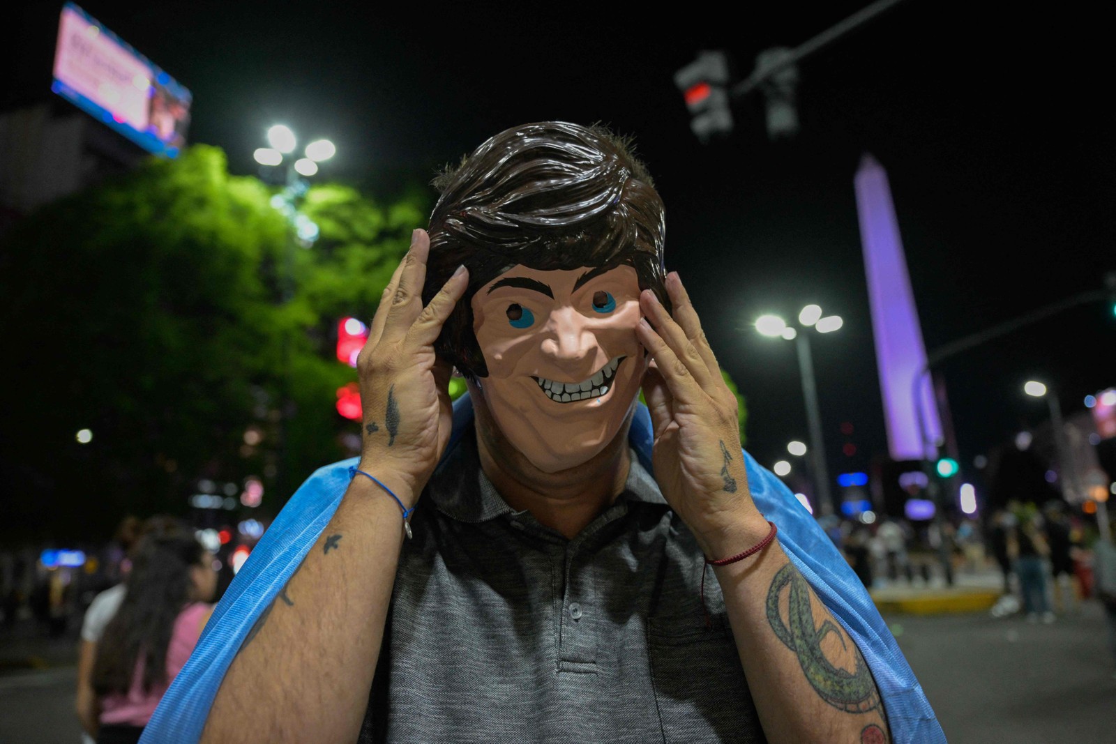 Apoiadores de Milei foram às ruas com máscara do presidente eleito — Foto: JUAN MABROMATA/AFP