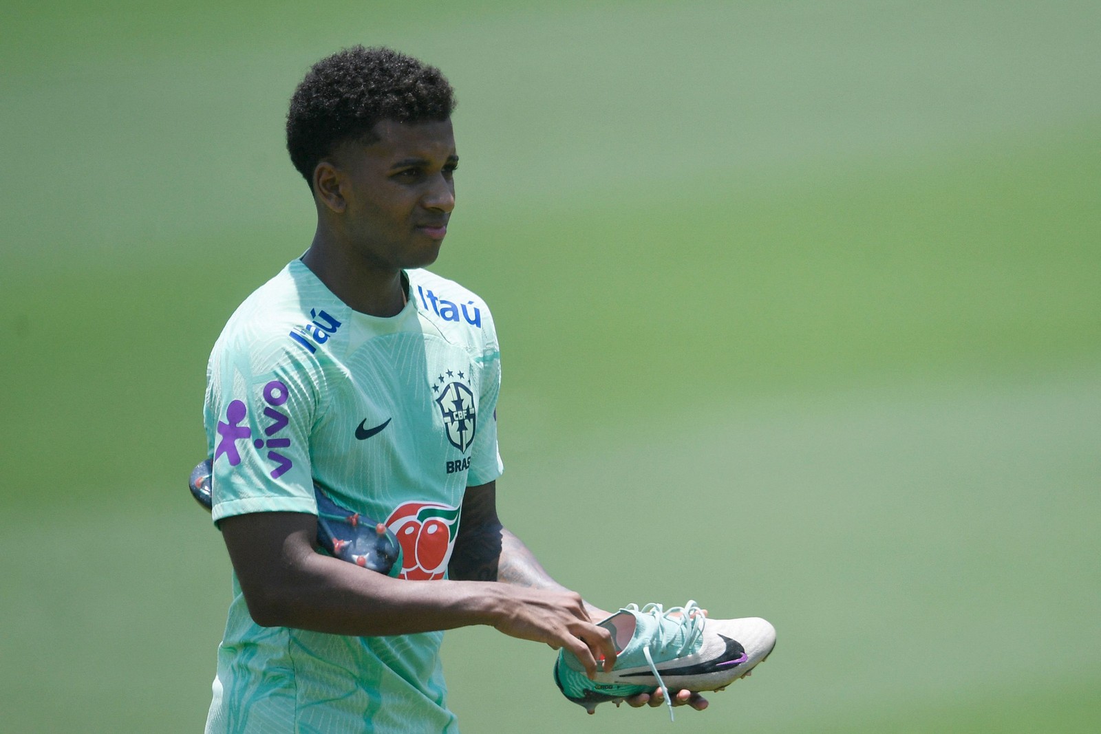 Rodrygo segura a chuteira durante treino pela seleção — Foto: Daniel Ramalho/AFP