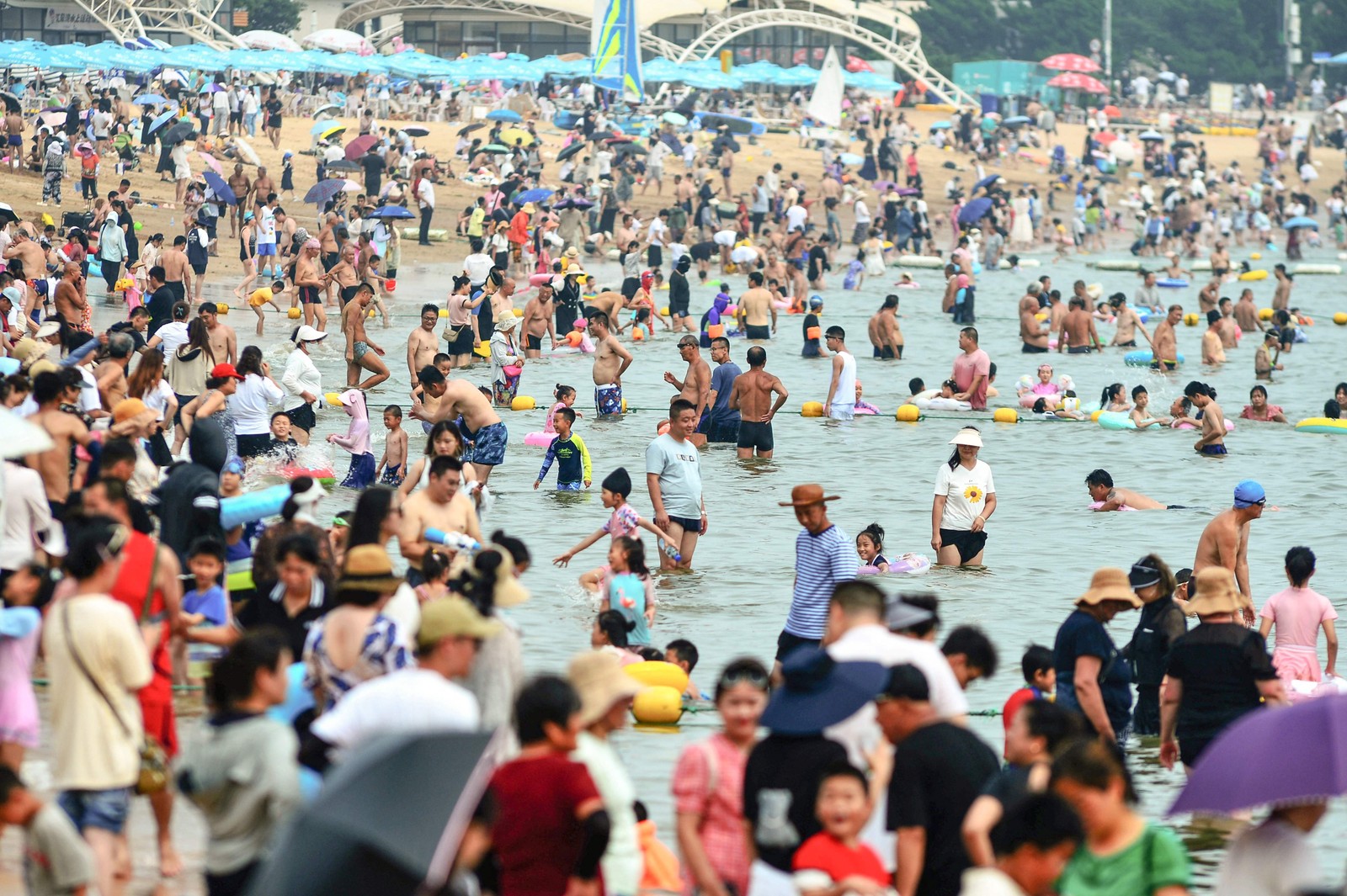 Pessoas se refrescam em uma praia em meio ao clima quente em Qingdao, na província de Shandong, no leste da China.  — Foto: AFP / China OUT