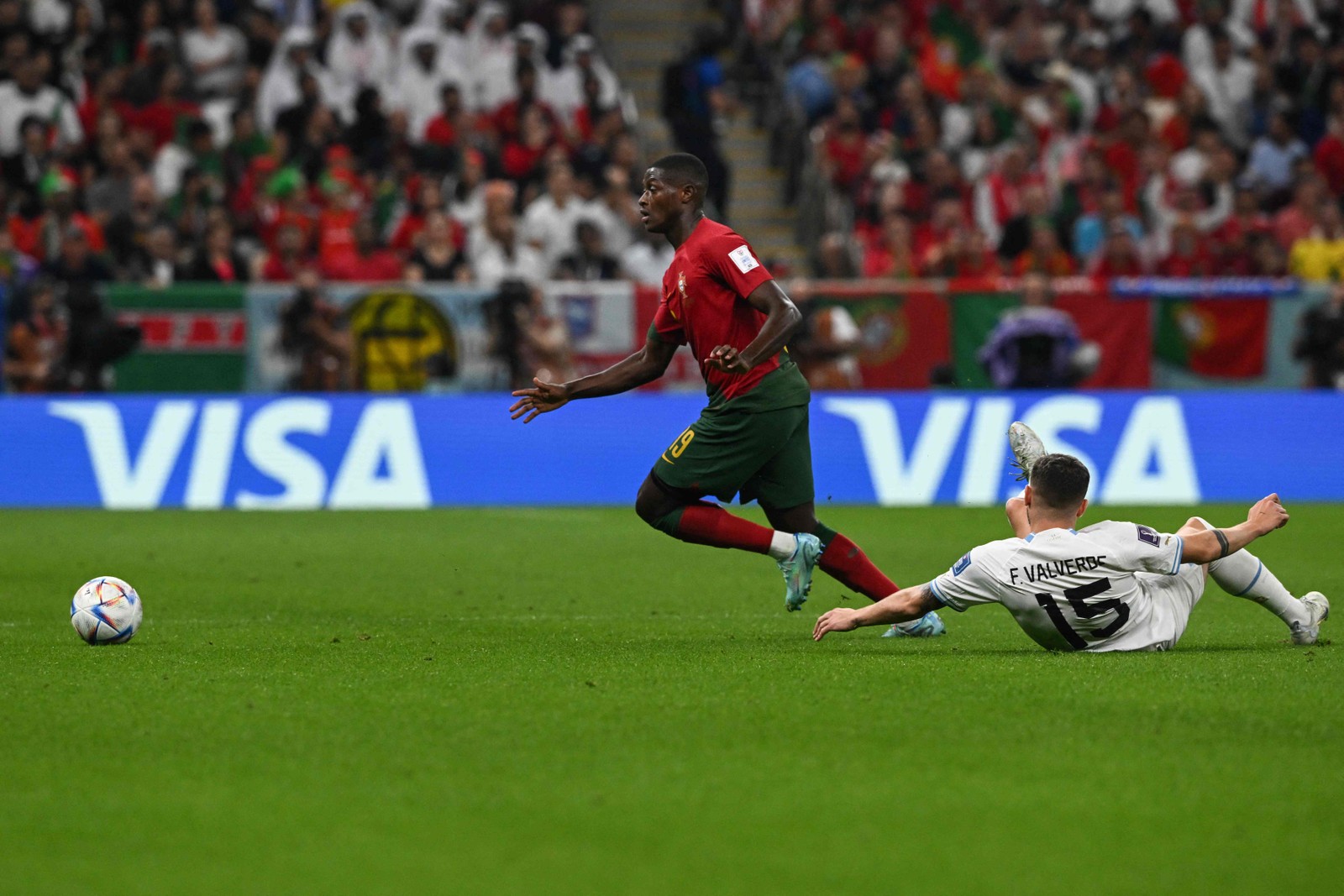 O zagueiro português Nuno Mendes passa pelo meia uruguaio Federico Valverde — Foto: Pablo PORCIUNCULA / AFP