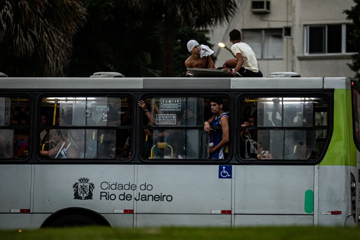 Passageiros viajam no teto de ônibus sem ar-condicionado na volta da praia — Foto: Hermes de Paula / Agencia O Globo