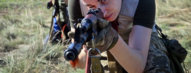 Cadetes ucranianas, vestindo novos uniformes militares projetados especialmente para mulheres, participam de um treinamento durante o evento "Uniform matters" (uniforme importa), organizado para apresentar a roupa e testá-la em condições de treinamento militar, nos arredores de Kiev — Foto: Sergei SUPINSKY / AFP