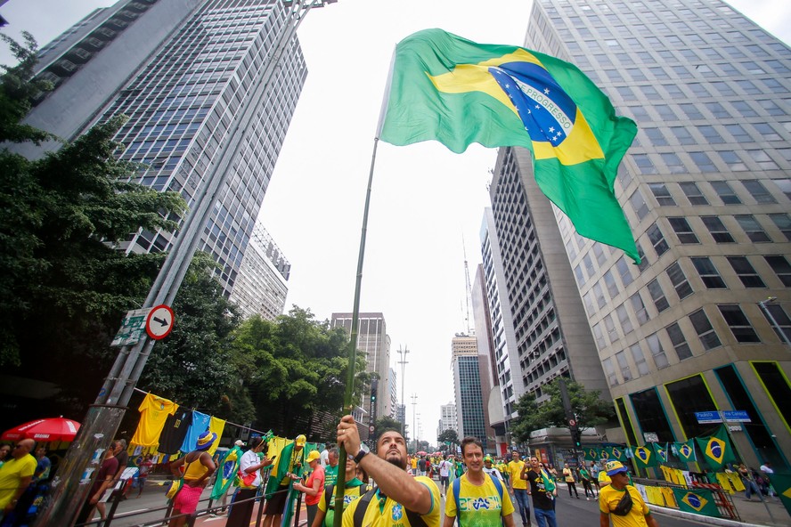 Apoiadores de Bolsonaro vestem camisas verdes e amarelas na Avenida Paulista, em São Paulo