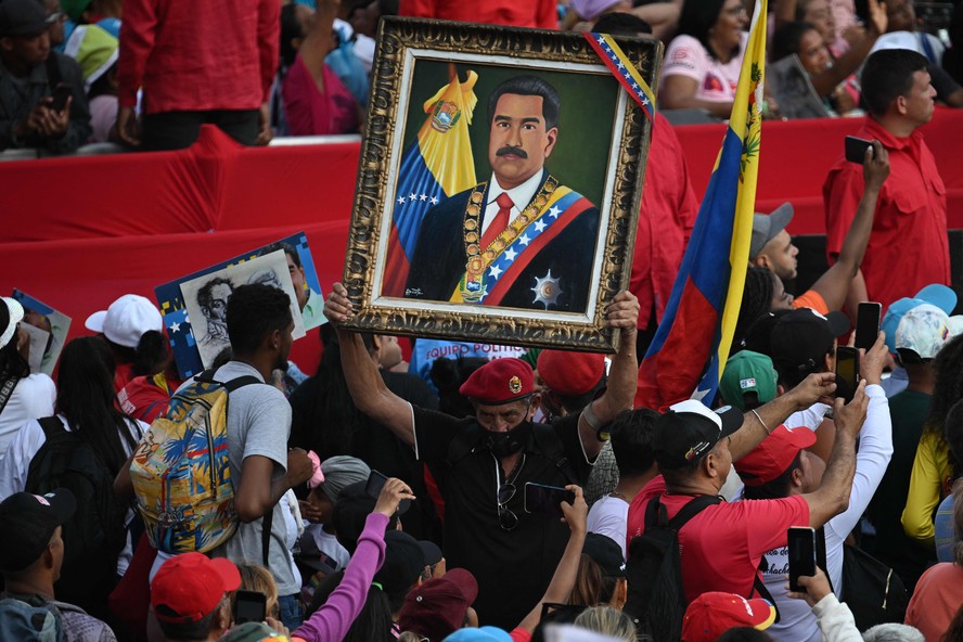 Apoiador de Maduro carrega quadro com imagem do presidente venezuelano