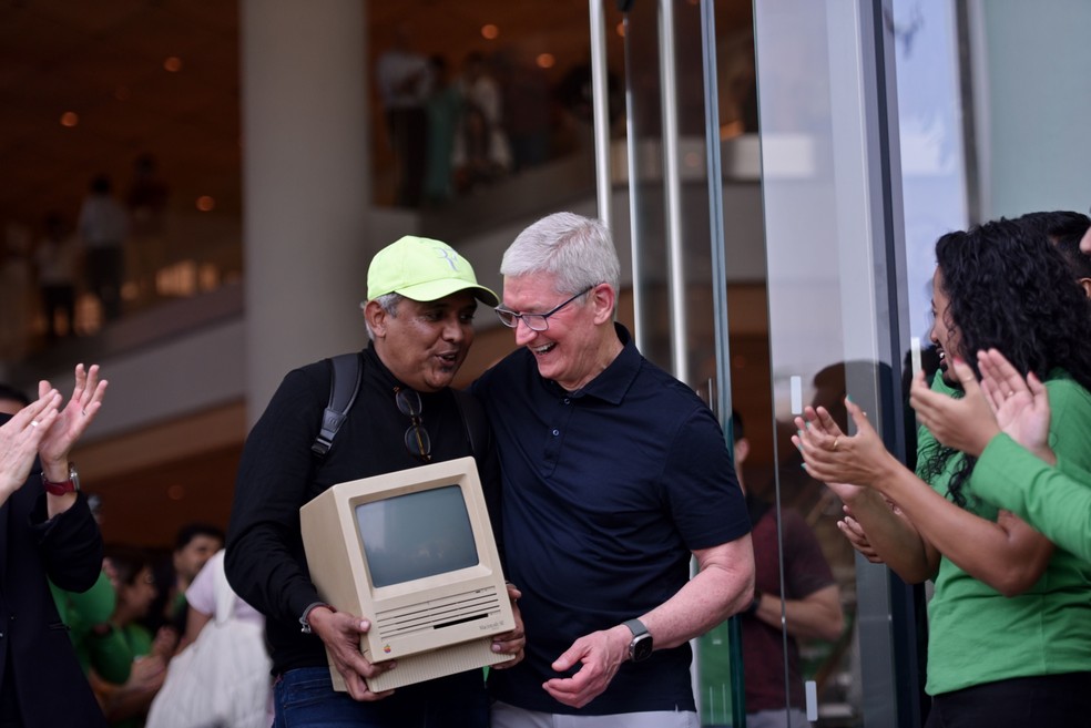 Tim Cook abraça um cliente que carregava uma réplica do Macintosh SE, primeiro computador da Apple criado em 1984, durante inauguração da loja da fabricante do iPhone em Mumbai, Índia — Foto: Indranil Aditya/Bloomberg