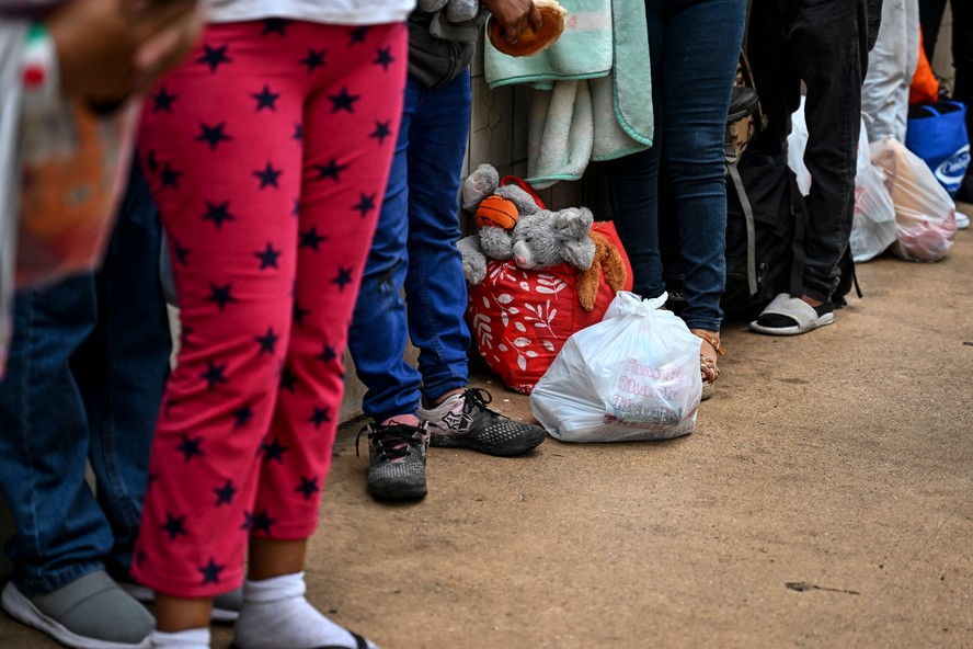 Fila de imigrantes na fronteira entre o México e os EUA: busca de vida melhor expõe ao risco de tráfico humano