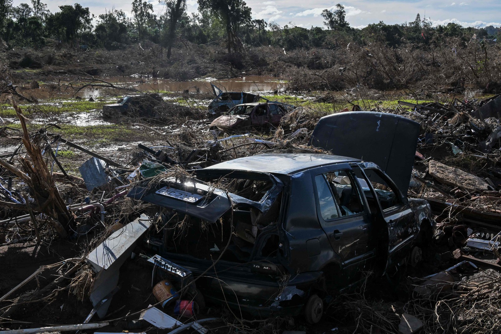 Carros destruídos e destroços são vistos em Cruzeiro do Sul — Foto: Nelson ALMEIDA / AFP