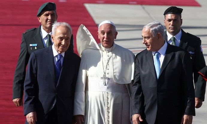 O Papa Francisco caminha ao lado do presidente israelense, Shimon Peres (esquerda), e do primeiro-ministro israelense, Benjamin Netanyahu, durante uma cerimônia de boas-vindas ao chegar ao aeroporto Ben Gurion, em maio de 2014, perto de Tel Aviv