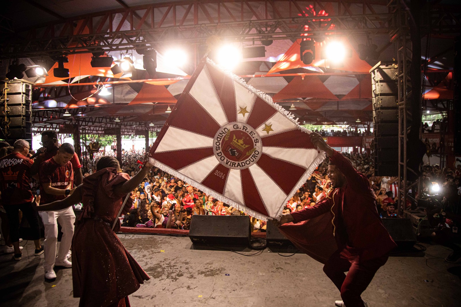 O casal de mestre-sala e porta-bandeira exibe o pavilhão da escola durante a festa na quadra— Foto: Hermes de Paula / Agência O Globo