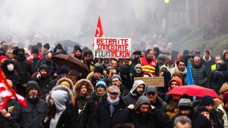 Cartaz pede saída de Emmanuel Macron do governo francês, devido à proposta de reforma da previdência — Foto: CHARLY TRIBALLEAU/AFP