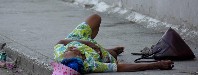 Uma mulher idosa, que foi baleada no pé, grita por socorro em Porto Príncipe, Haiti. — Foto: Clarens SIFFROY / AFP