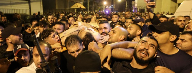 Homens carregam o corpo do suposto líder da Lion's Den de um hospital em Nablus depois que ele foi morto em um confronto com soldados israelenses, na Cisjordânia. No total, quatro palestinos foram mortos mortos e quase 20 outros feridos — Foto: JAAFAR ASHTIYEH/AFP