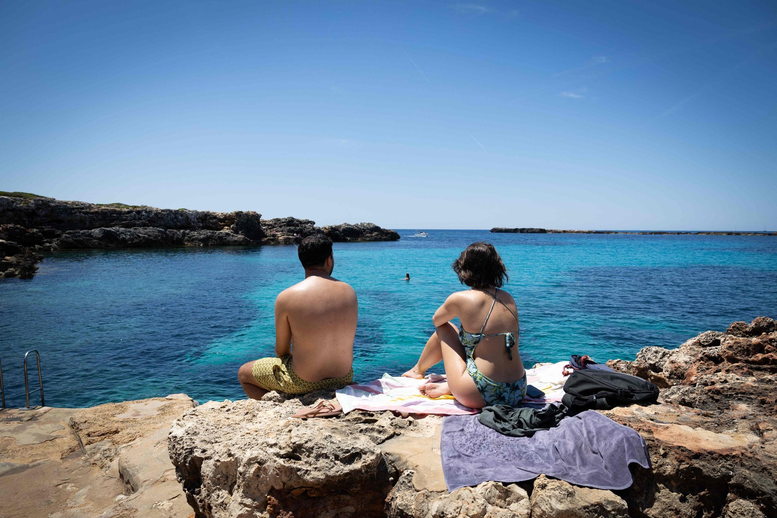 Turistas aproveitam a praia que fica fora da área com horário de visitação restrito de Binibeca Vell, na ilha de Menorca, Espanha — Foto: Jaime Reina / AFP