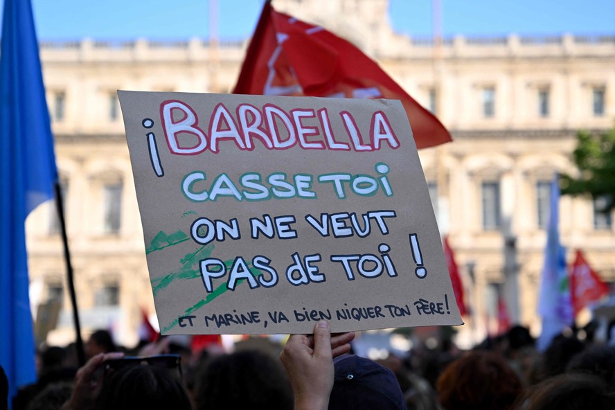 Um manifestante segura um cartaz que diz 'Bardella: vá embora, não queremos você aqui' durante uma manifestação contra o partido francês de extrema direita 'Rassemblement National' (RN) em Marselha, sul da França, em 10 de junho de 2024, um dia depois que o partido venceu as eleições europeias na França.