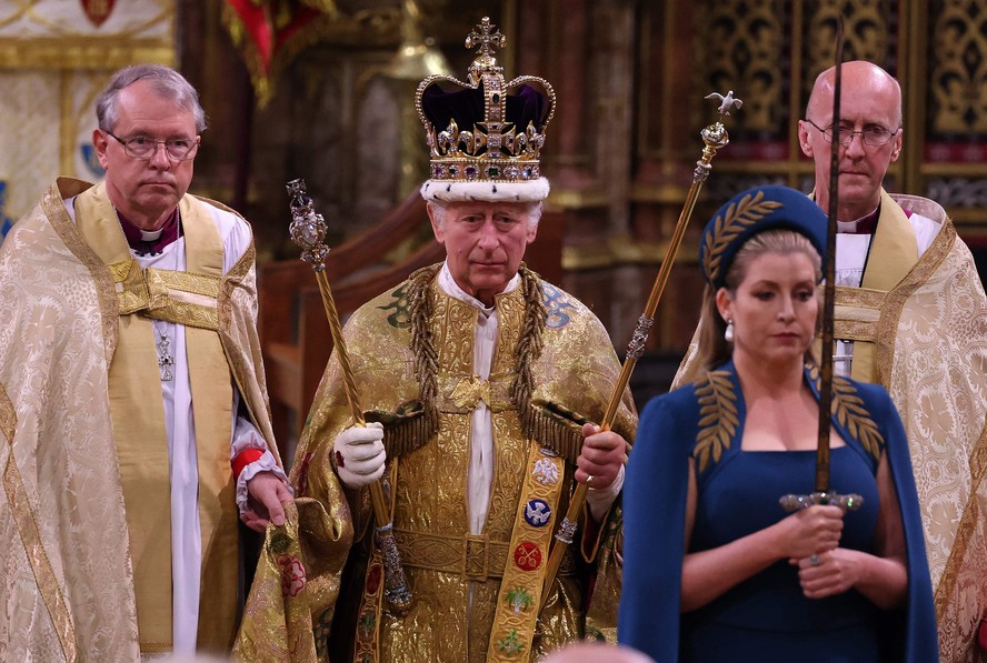 O rei Charles caminha vestindo a Coroa de Santo Eduardo durante a cerimônia de coroação na Abadia de Westminster