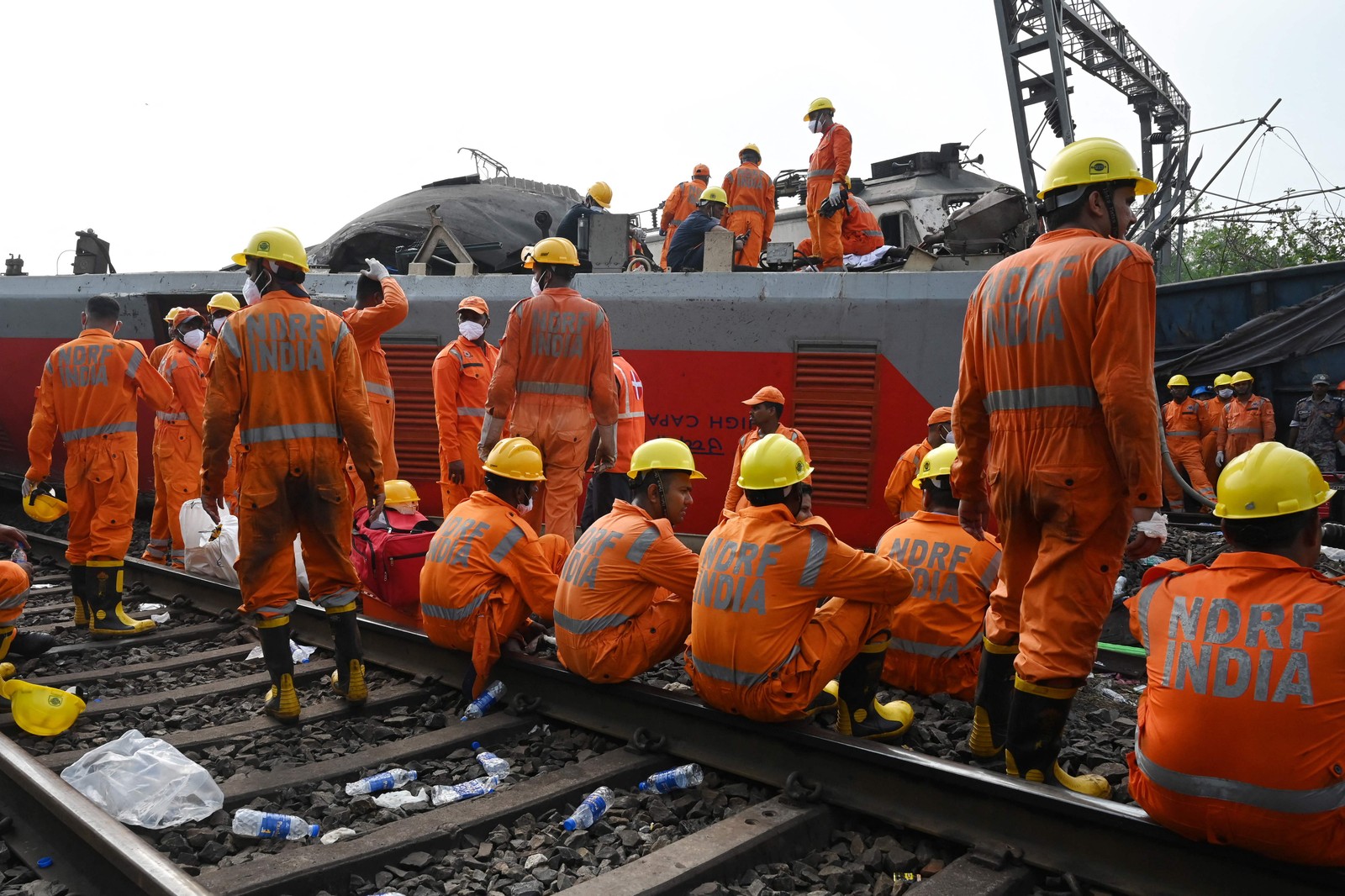 Equipes de resgate se reúnem em torno dos trens danificados no local da colisão perto de Balasore, a cerca de 200 km da capital do estado Bhubaneswar — Foto: DIBYANGSHU SARKAR / AFP