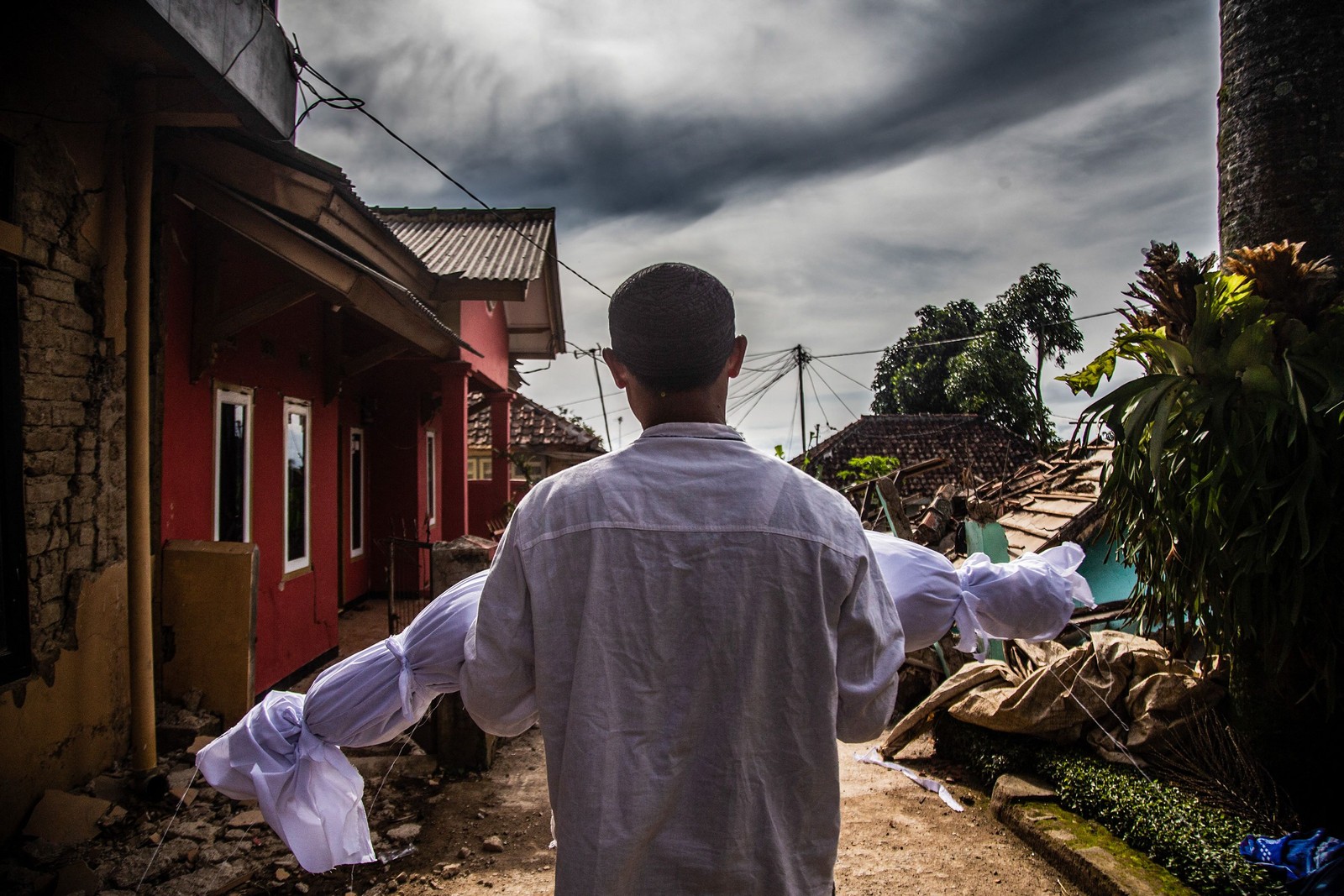 Aldeão carrega o corpo de seu filho morto após um terremoto em Cianjur, na Indonésia, em 22 de novembro.  — Foto: ADITYA AJI / AFP