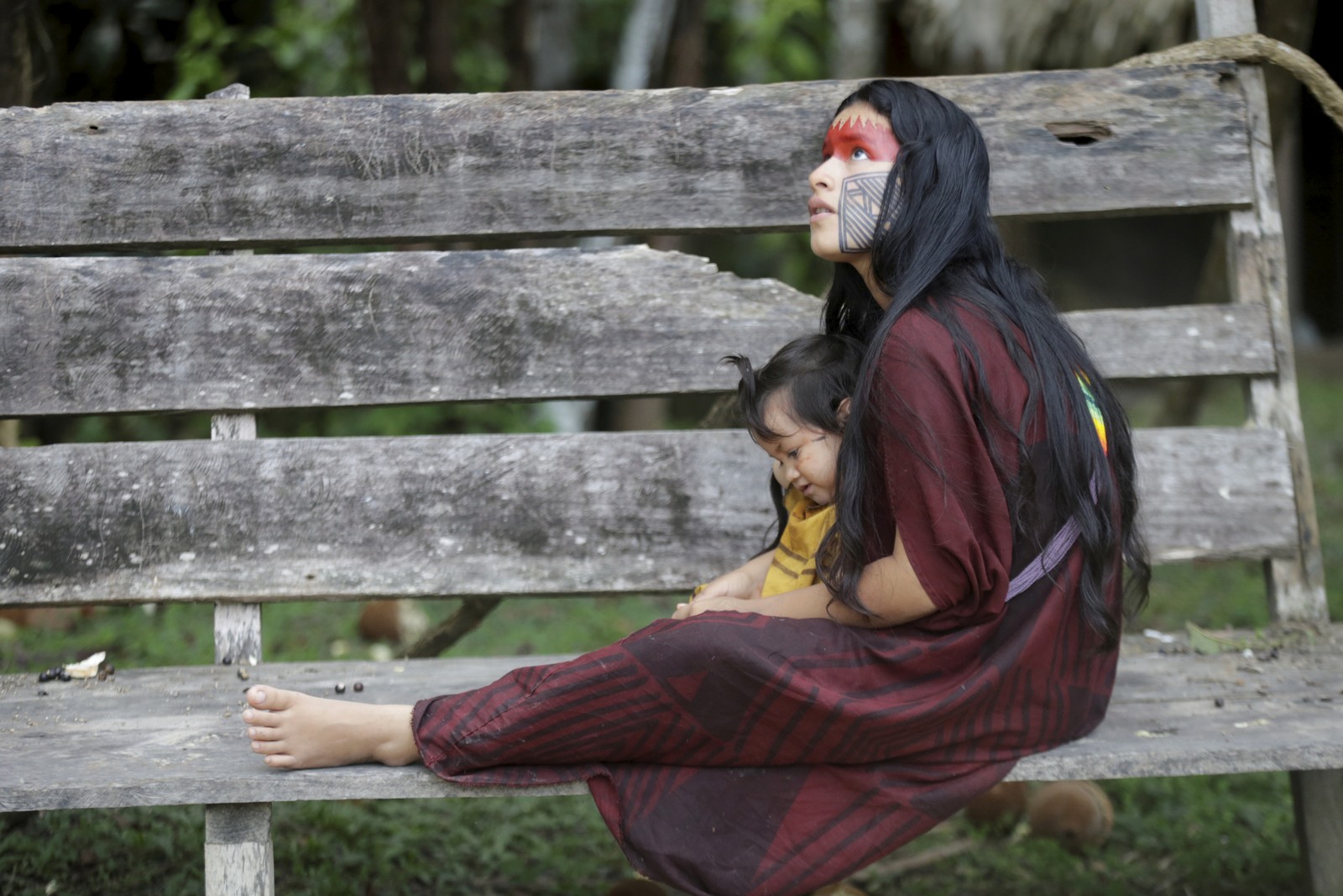 Bianca Pyãko, filha da líder Dora Pyãko, carrega sua irmã durante reunião das lideranças ashaninkas e kayapós -  Foto: Domingos Peixoto / Agência O Globo