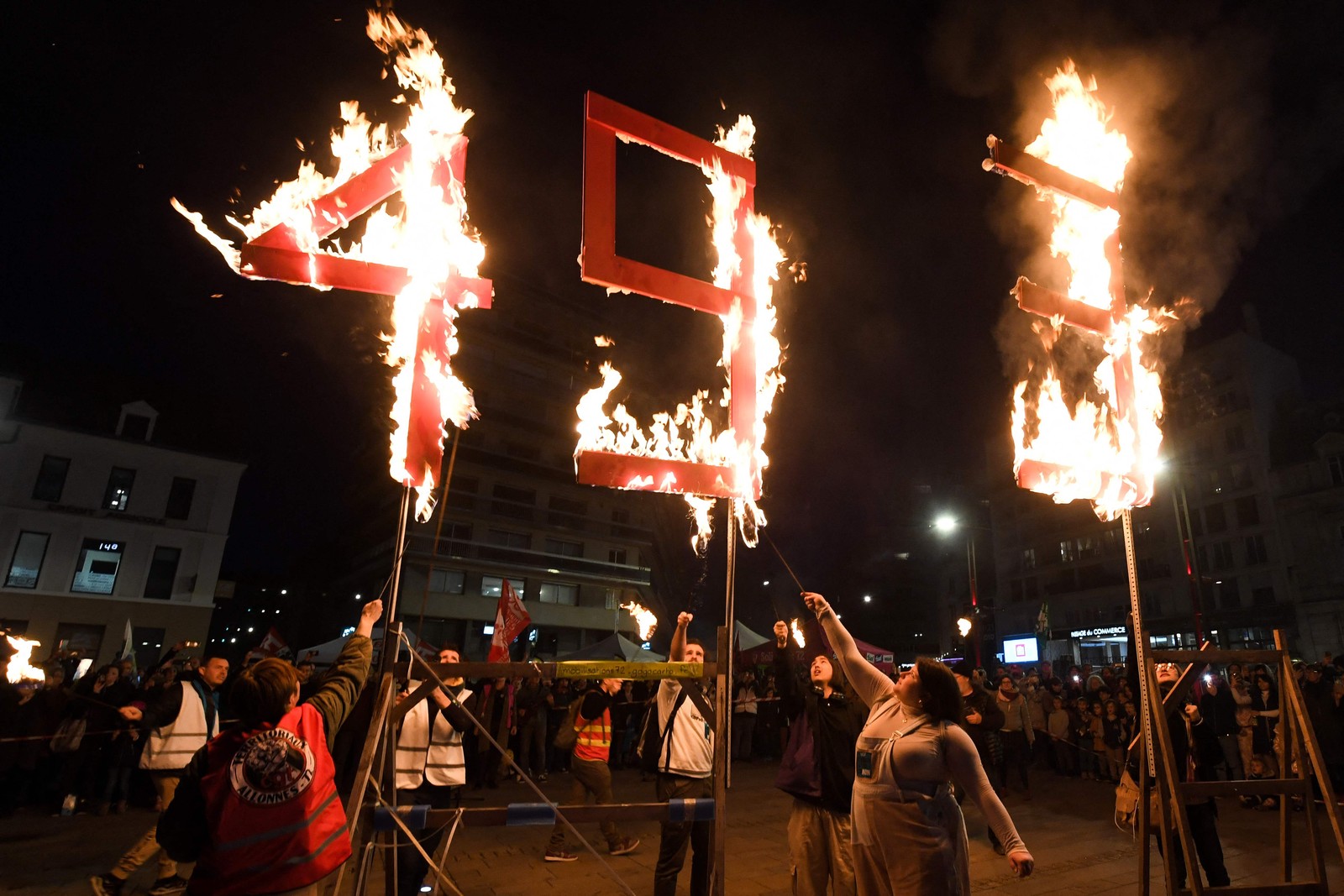 Manifestantes em Le Mans queimam o número 49.3, em referência ao artigo da manobra constitucional de Macron para aumentar a idade mínima de aposentadoria em dois anos na França — Foto: JEAN-FRANCOIS MONIER/AFP