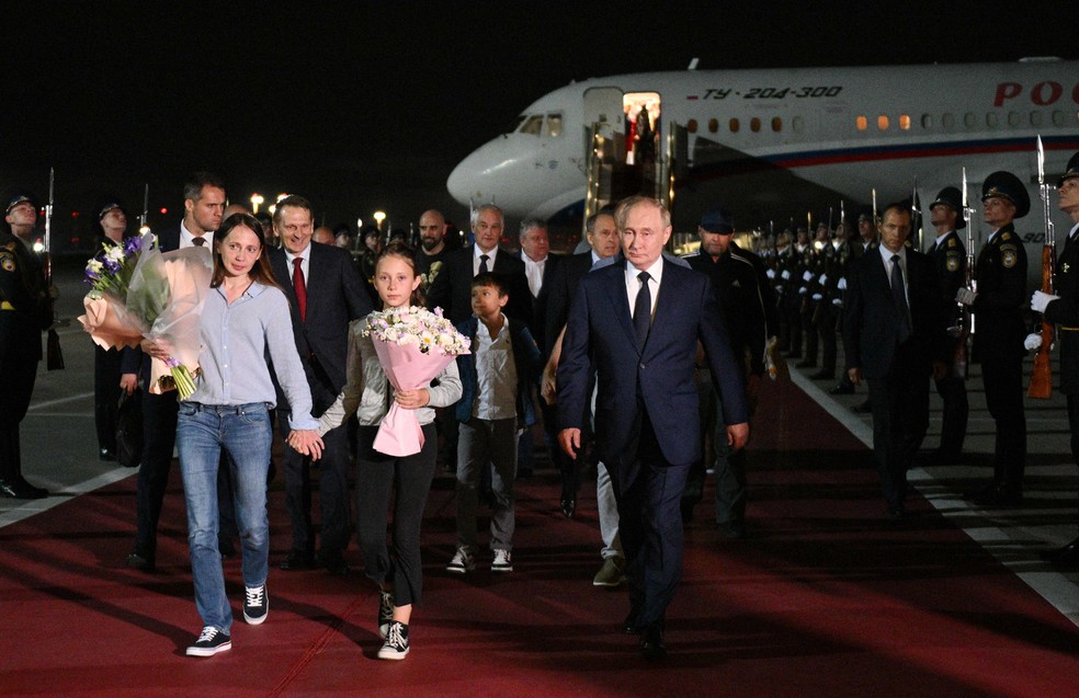 Presidente da Rússia, Vladimir Putin, acompanha russos libertados em troca de prisioneiros com o Ocidente, no aeroporto Vnukovo, em Moscou — Foto: Kirill ZYKOV / POOL / AFP