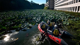 Equipe de resgate do Departamento de Polícia Metropolitana de Tóquio procura um fosso no Parque Kitanomaru em busca de objetos perigosos, em Tóquio — Foto: Kazuhiro NOGI / AFP