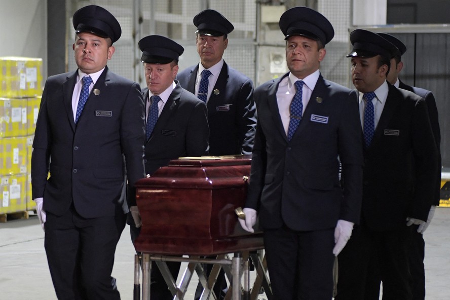 Homens carregam caixão de Fernando Botero no Aeroporto Internacional de Bogotá