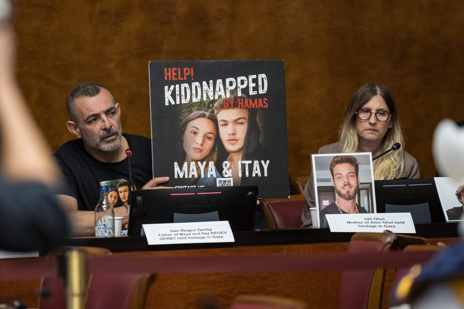 Ilan Regev Gerby mostra foto de seus dois filhos, Maya e Itay, mantidos reféns em Gaza. Ao lado, à direita, Idit Ohel, mãe de Alon Ohel, também mantido refém em Gaza — Foto: PIERRE ALBOUY / AFP