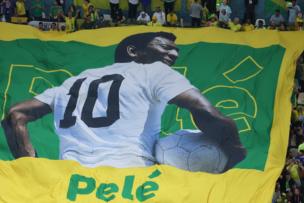 Torcida brasileira estende bandeirão em homenagem a Pelé antes do jogo contra Camarões, pela Copa do Catar — Foto: Giuseppe Cacace/AFP