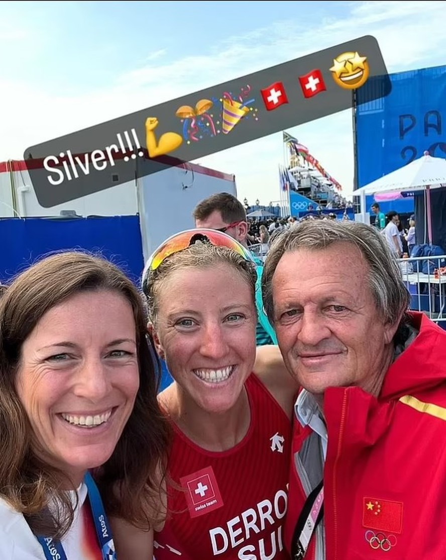 Na imagem é possível ver Brett Sutton com o casaco e credencial da China ao lado da medalhista Julie Derron