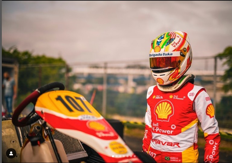  No capacete, ela carrega três bandeiras: da Bélgica, Estados Unidos e a do Brasil, em que faz homenagem a Ayrton Senna  — Foto: Reprodução Instagram
