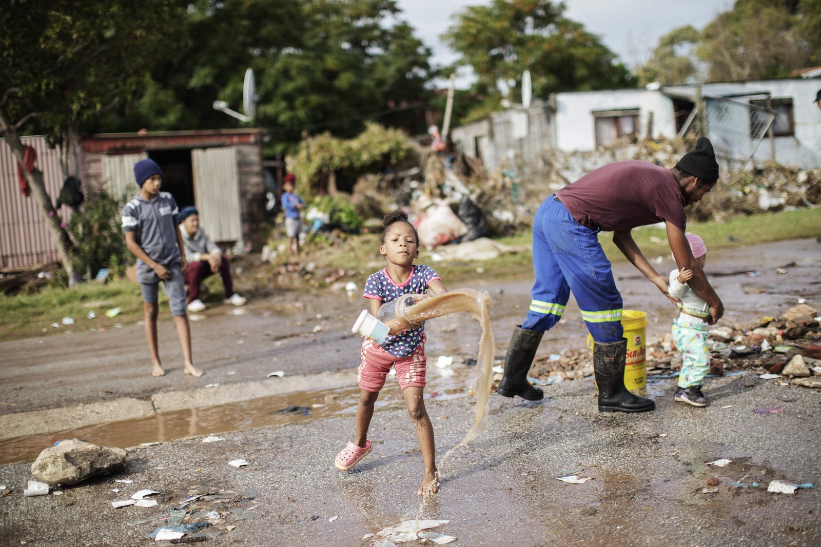 Moradores limpam as águas das enchentes de suas casas. As enchentes causadas por chuvas torrenciais e ventos fortes na costa leste da África do Sul mataram pelo menos 22 pessoas, disseram as autoridades locais na terça-feira. As inundações atingiram vários locais em duas províncias do leste, dois raros tornados foram detectados, as temperaturas caíram e a neve caiu em algumas regiões centrais. — Foto: GIANLUIGI GUERCIA/AFP