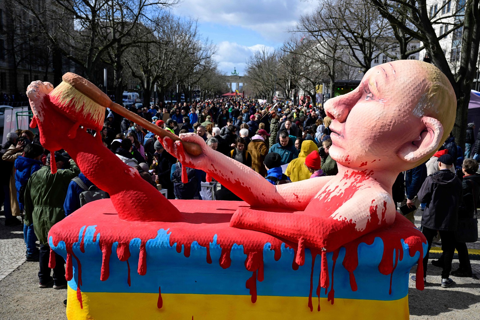 Boneco do presidente russo, Vladimir Putin, em uma banheira de sangue é vista durante comício em frente à embaixada russa em Berlim, onde eleitores fizeram fila para votar nas eleições presidenciais russas de 17 de março de 2024. — Foto: Tobias SCHWARZ / AFP