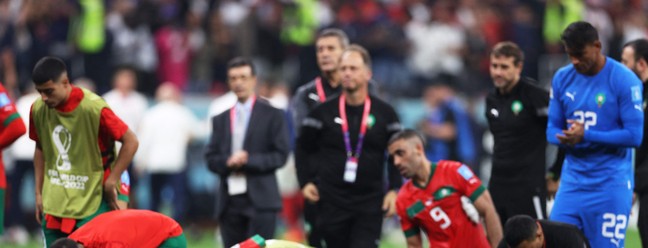 Em gesto de reverência, marroquinos rezam para a torcida após derrota por 2 a 0. Foi a melhor campanha africana na história das Copas — Foto: ADRIAN DENNIS/AFP