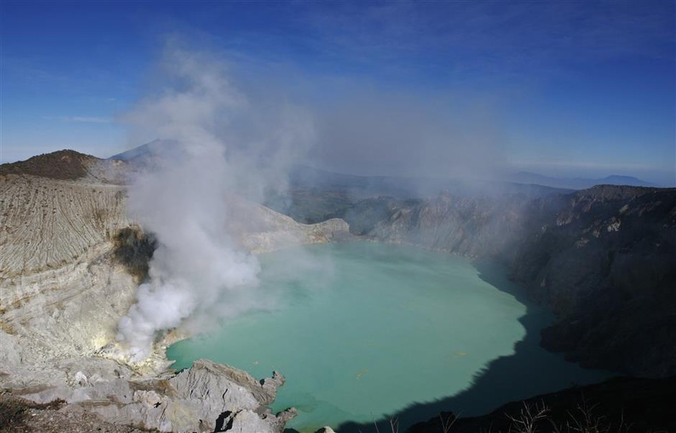 Monte Ijen, na Indonésia, é conhecido pelo fogo e fumaça de coloração azulada devido ao gás sulfúrico que emana da cratera. — Foto: Reprodução