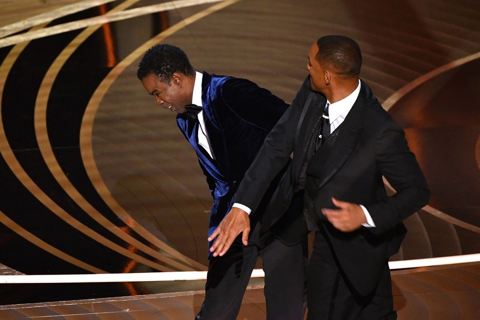 O ator Will Smith dá um tapa no ator Chris Rock durante a 94ª premiação do Oscar, em Hollywood, Califórnia, em 27 de março.  — Foto: Robyn Beck / AFP