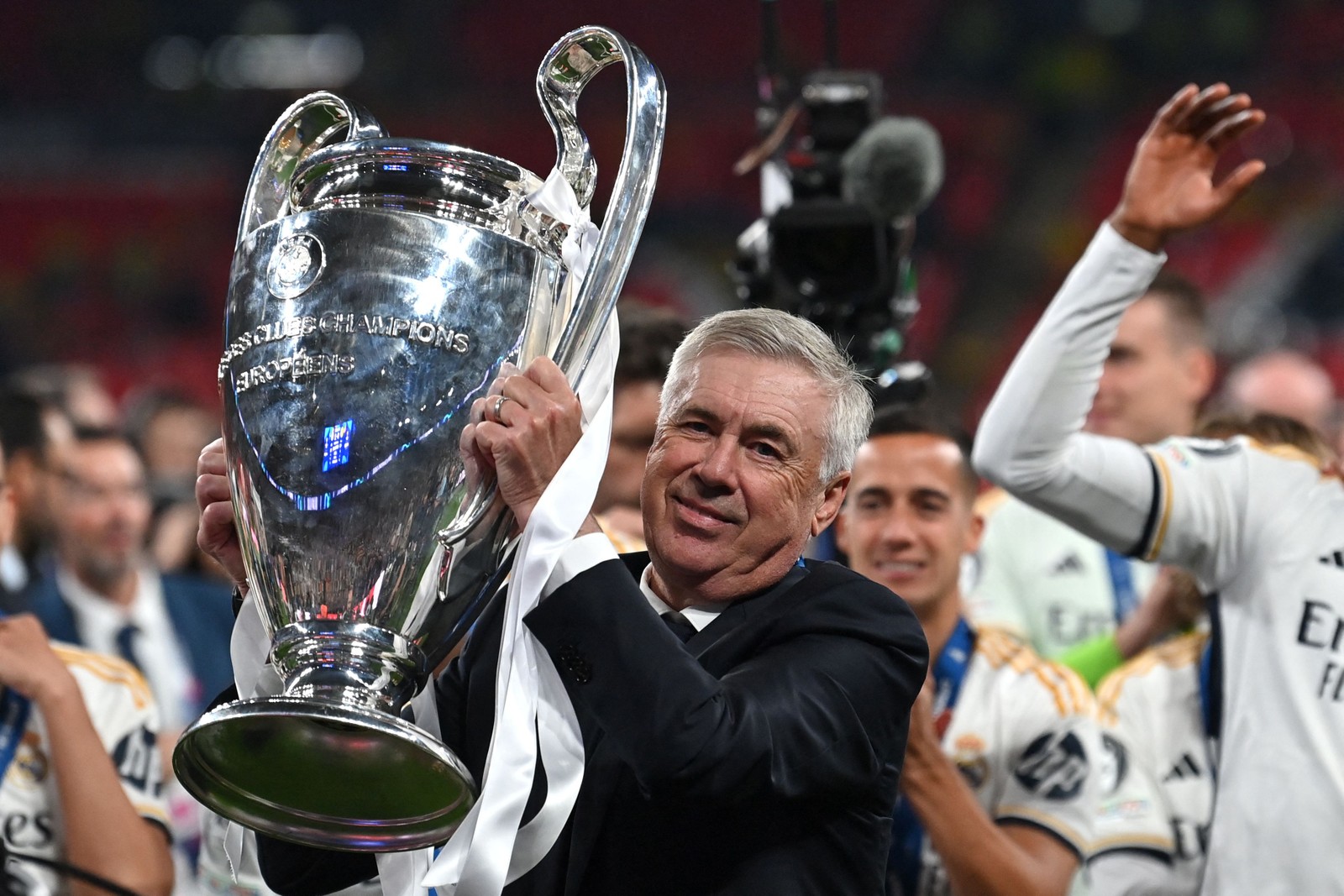 O técnico italiano do Real Madrid, Carlo Ancelotti, levanta o troféu para comemorar a vitória ao final da final da UEFA Champions League entre Borussia Dortmund e Real Madrid, no estádio de Wembley, em Londres, no dia 1º de junho de 2024. — Foto: Glyn Kirk/AFP