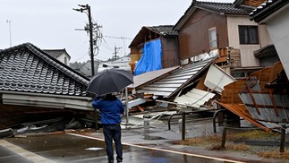 Fortes chuvas e ruas bloqueadas pelos escombros de casas dificultaram as ações de resgate no Japão — Foto: KAZUHIRO NOGI/AFP