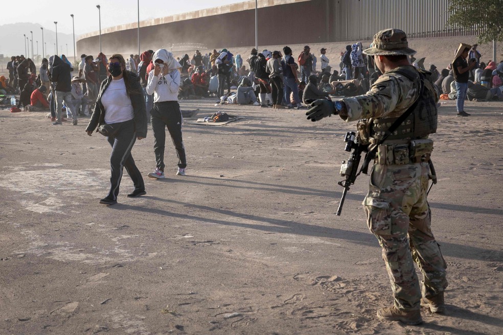 Soldado da Guarda Nacional do Texas direciona imigrantes que cruzaram a fronteira dos EUA. — Foto: John Moore/Getty Images/AFP