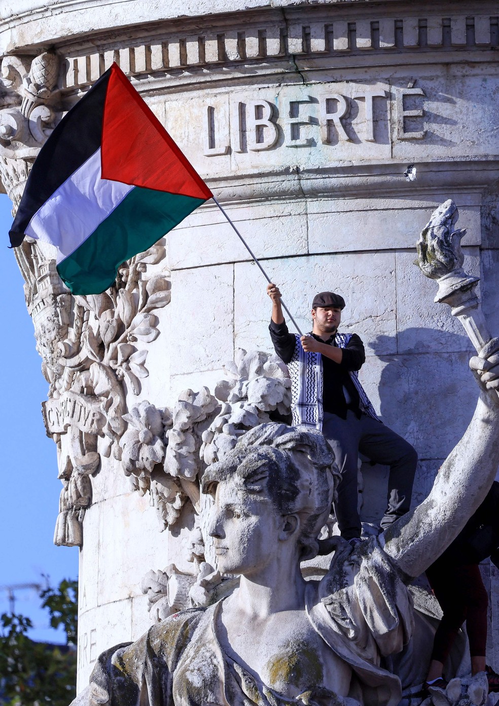 Manifestante agita uma bandeira palestina no Monument a la Republique, durante um ato em solidariedade à Gaza em Paris, em 22 de outubro — Foto: Emmanuel Dunand / AFP