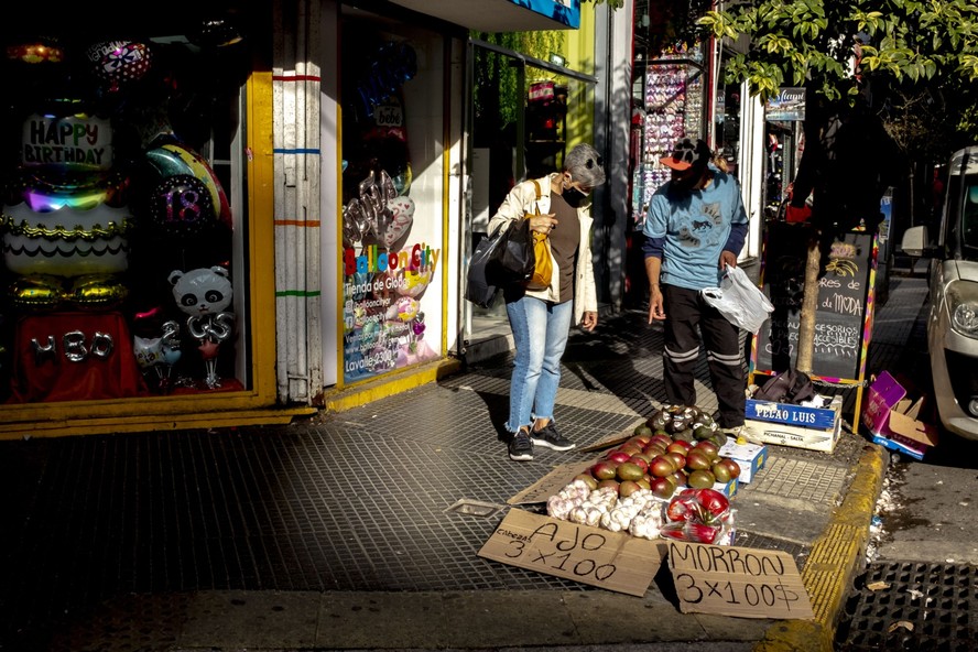 Ambulante vende frutas e legumes no bairro de Balvanera, em Buenos Aires, Argentina