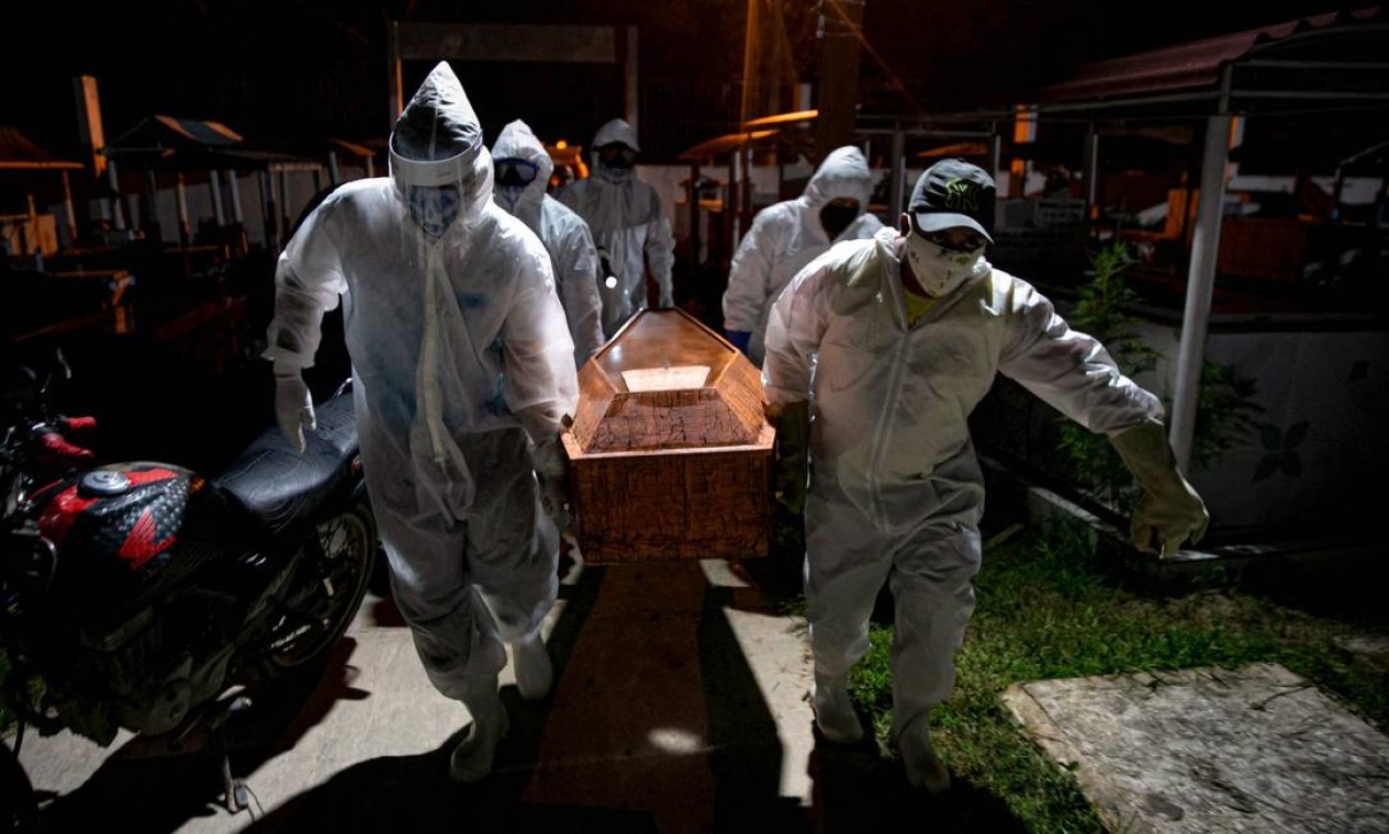 Coveiros em trajes de proteção carregam o caixão de uma vítima do novo coronavírus no cemitério Recanto da Paz, no Pará — Foto: TARSO SARRAF / AFP