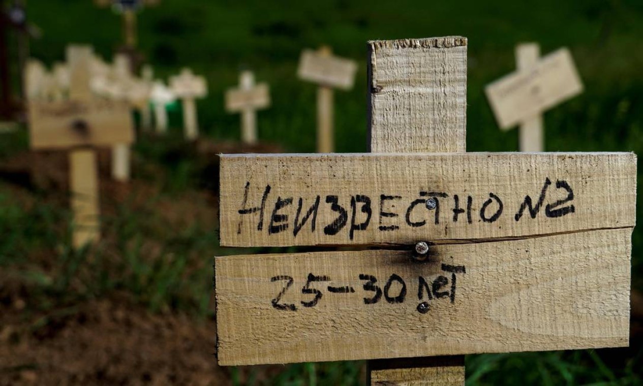 Guerra na Ucrânia. Em lápide improvisada e recém-colocada no cemitério de Mariupol se lê a "Desconhecido"  — Foto: STRINGER / AFP